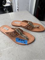 Top view of both sandals showing braided brown straps and rhinestone center detail