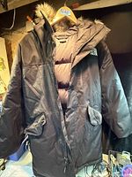 Full front view of coat on hanger showing overall style and pockets