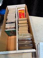 Two-row card storage box filled with loose cards; unopened Central Red Army set visible