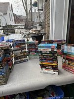 Multiple stacks of VHS tapes on outdoor table