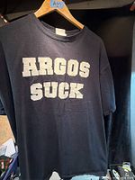 Front of black T-shirt with "ARGOS SUCK" text