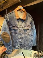Front view showing denim body, corduroy collar, chest pockets, button front