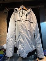 Full front view of off-white Point Zero hooded winter coat on hanger