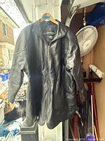 Full view of front of black leather jacket hanging