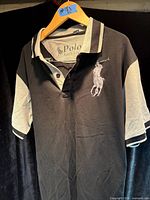 Front view of black and grey Polo Ralph Lauren pullover shirt on hanger