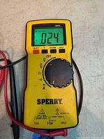 Front view of Sperry DM-6800 multimeter displaying 0.24 V with attached red and black leads