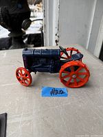 Side view of blue Fordson metal toy tractor with red wheels