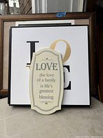 Front view showing plaque, LOVE print, other frames behind