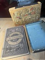 Closed hardcover cookbook beside open two-piece illustrated box