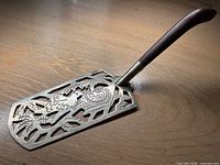 Full view of cake server showing blade pattern and handle