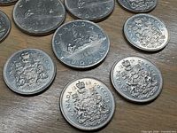 Group of Canadian dollar and fifty-cent coins showing dates and designs