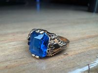 Three-quarter view of ring showing stone and ornate setting