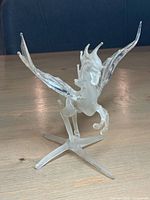 Full view of glass Pegasus standing on X-shaped base