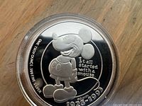 Close-up of coin obverse showing Mickey design and purity legend