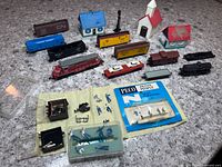Overall lot showing locomotive, freight cars, buildings, figures, parts