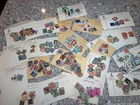 Overview of all envelopes with assorted stamps spread out on countertop