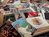 Scattered selection of Royal Family postcards on table