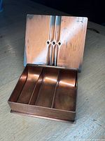 Box open showing interior compartments and lid motif