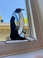 Full view of stained glass penguin panel on window