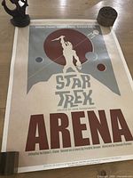 Full view of rolled Star Trek Arena poster with weights on corners