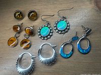 All five pairs of sterling earrings arranged on wooden surface