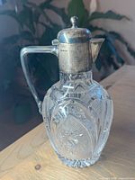 Full view of claret jug showing crystal pattern and sterling fittings