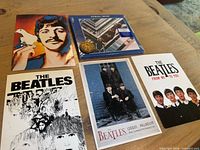 All six items laid out: sealed CD, coin, four postcards
