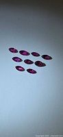 All ten marquise-cut rubies arranged on neutral background