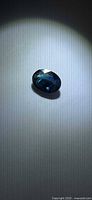 Top view of oval blue sapphire under spotlight