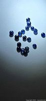 Group of small round blue sapphire cabochons on neutral background