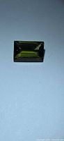 Top view of rectangular green tourmaline showing baguette cut and color