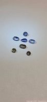 Six faceted tanzanite gemstones arranged on white background