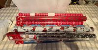 Ten sealed rolls of wrapping paper laid flat