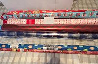 Ten assorted wrapping paper rolls laid out showing various patterns and labels