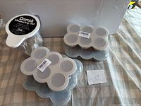 Dansk measuring pitcher with lid beside multiple baby food freezer trays