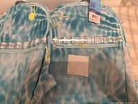 Two blue water-pattern Ecotech Riley backpacks side by side showing fronts and zippers