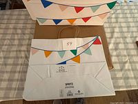 Front and back view of Spritz gift bags showing bunting print and handles