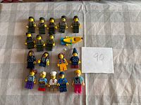 All 18 minifigures and yellow kayak laid out on table