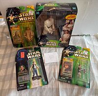 Group shot of four sealed Star Wars figures on table