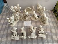 Wide view of all Snowbabies figurines arranged on table