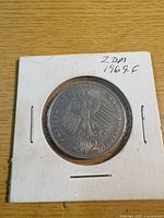 Coin in cardboard flip, obverse with eagle visible