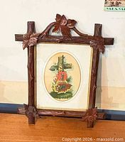 Full view of framed print showing carved wood frame and artwork