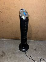 Full view of black Honeywell QuietSet tower fan with cord and base