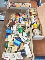 Overview of two open boxes filled with assorted vintage matchbooks