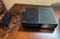 Top view of Xbox One console with power brick and cable