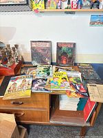 Full view of mixed lot on tabletop showing variety of books, magazines and comics