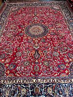 Full view of red Isfahan Persian rug showing central medallion and borders
