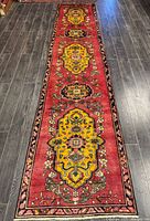 Full view of entire runner rug on dark wood floor