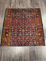 Full overhead view of the entire handmade Hamadan rug on wood floor