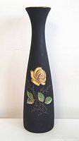 full view of tall matte black porcelain vase with painted rose design